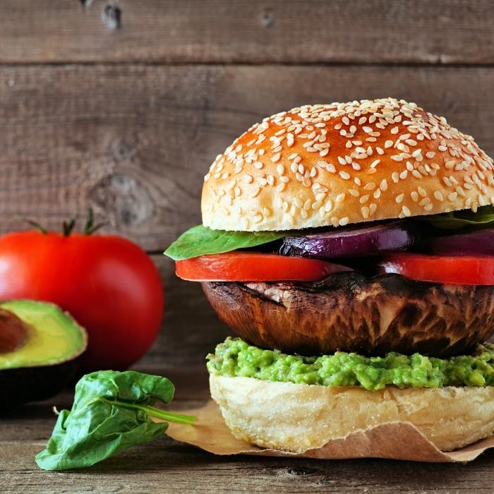 Portobello vegan mushroom burger with avocado and tomato.
