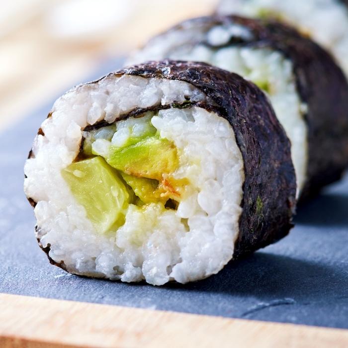 Vegan sushi roll with nori, rice, avocado, and cucumber.