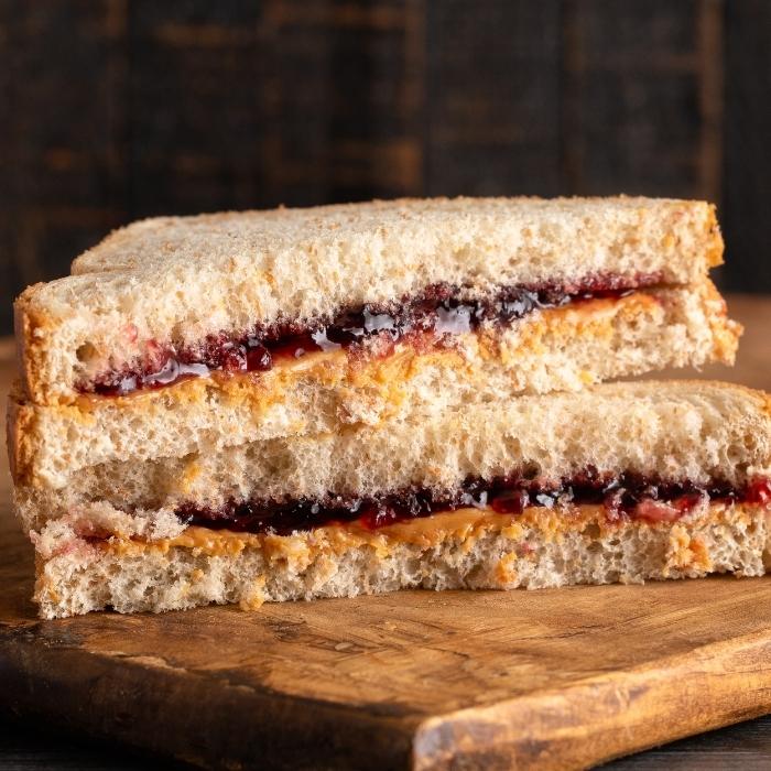 Close up of peanut butter and jelly sandwich cut diagonally.
