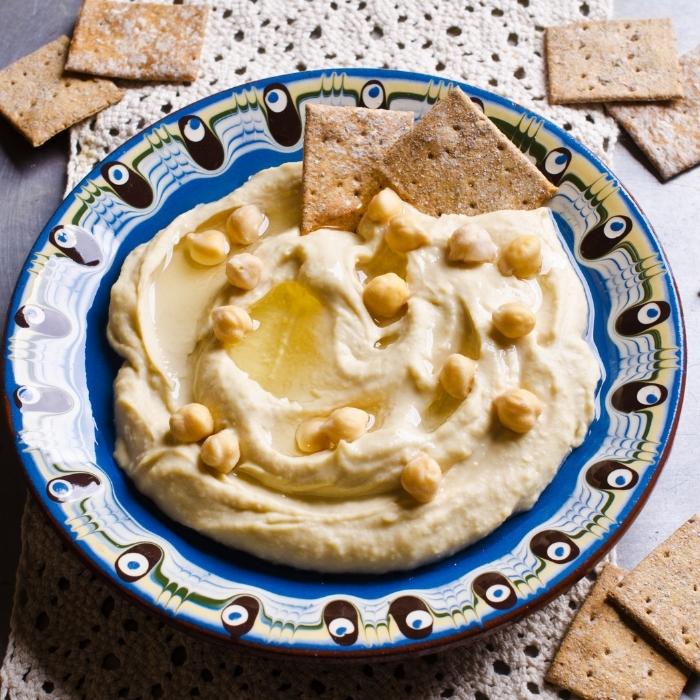A bowl of creamy hummus garnished with chickpeas.