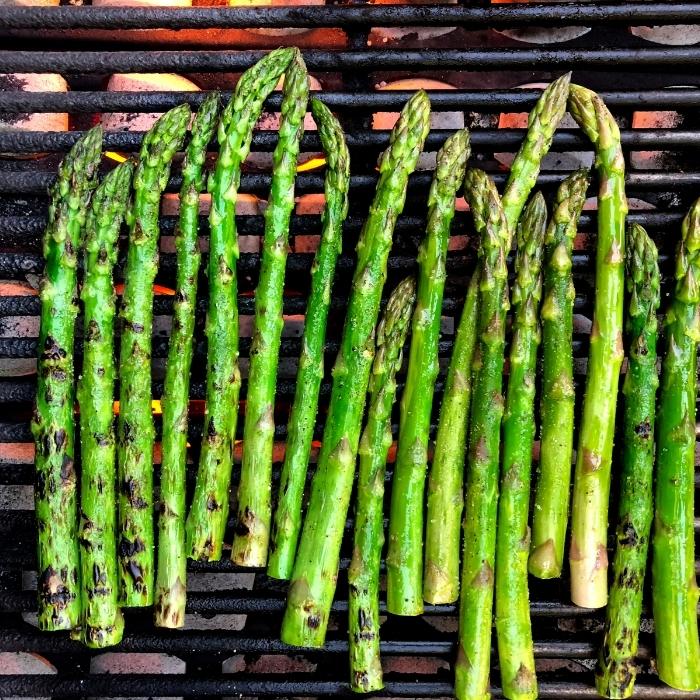 Asparagus spears on a charcoal grill.