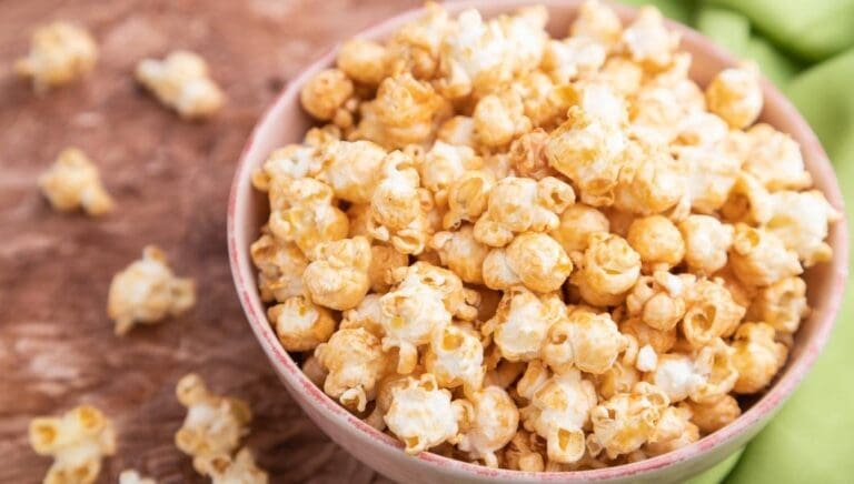 Close up bowl of caramel popcorn on a table.