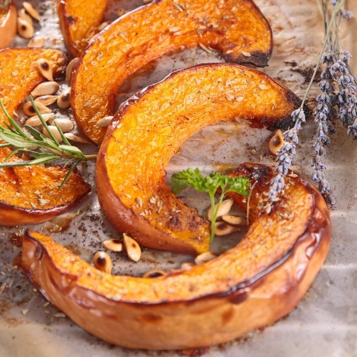 Slices of roasted pumpkin on parchment paper.