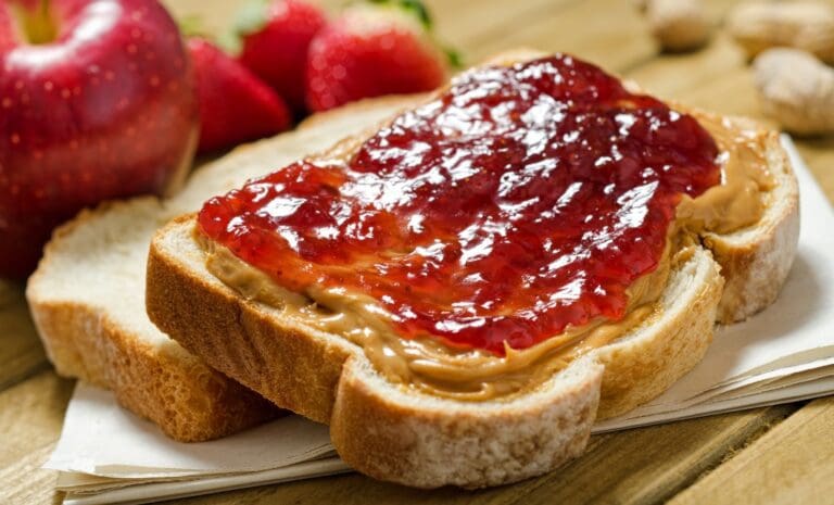 Slice of bread with peanut butter and jam.