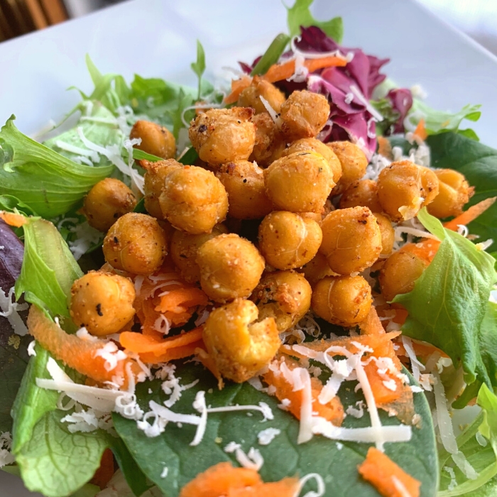 Roasted chickpeas with spring salad greens and vegan cheese.