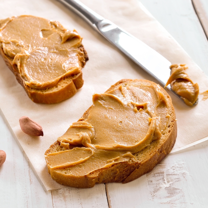 Toasted bread with peanut butter on a table.
