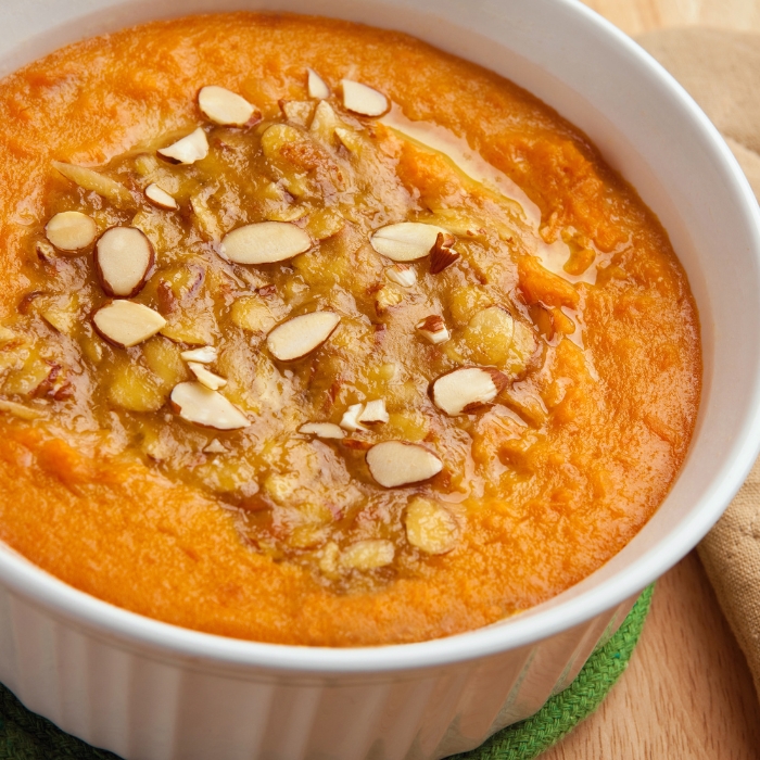 A dish of sweet potato casserole with slivered almonds.