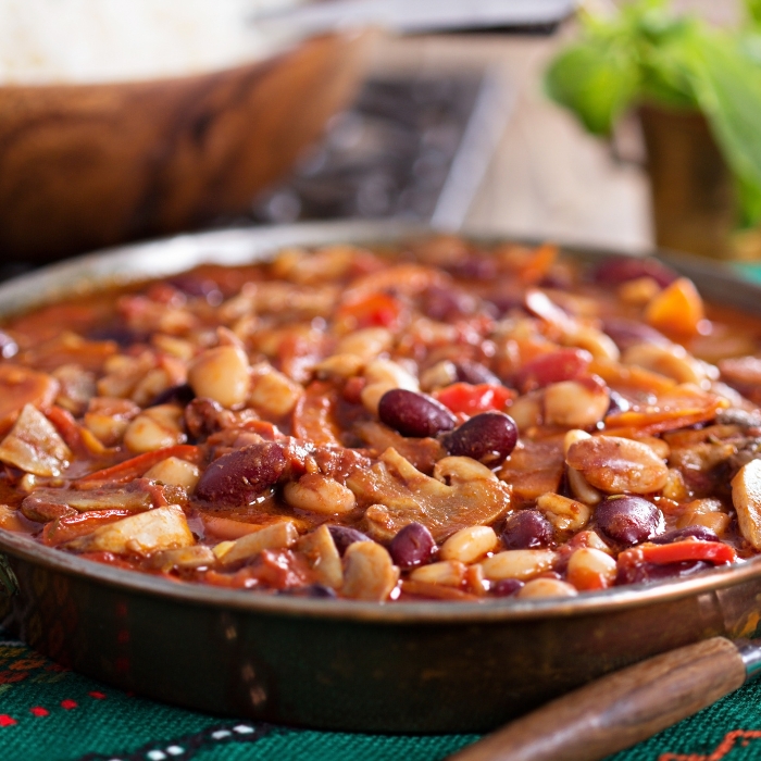 Pan of spicy vegan chili with beans and mushrooms.