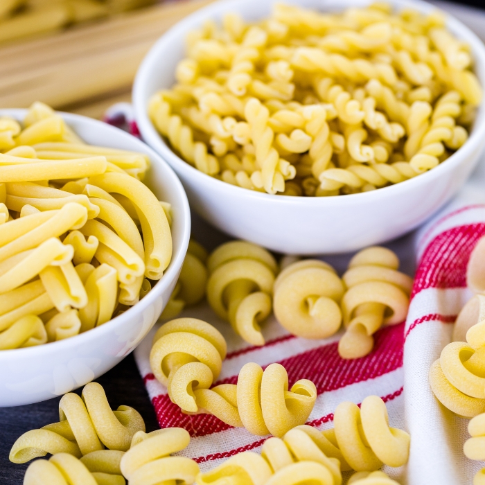 Various dry kinds of pasta in bowls.